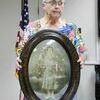 Jan Crow displays unusual curved
photo, with curved glass, of her
ancestor. (Photo by Tom Tyler)